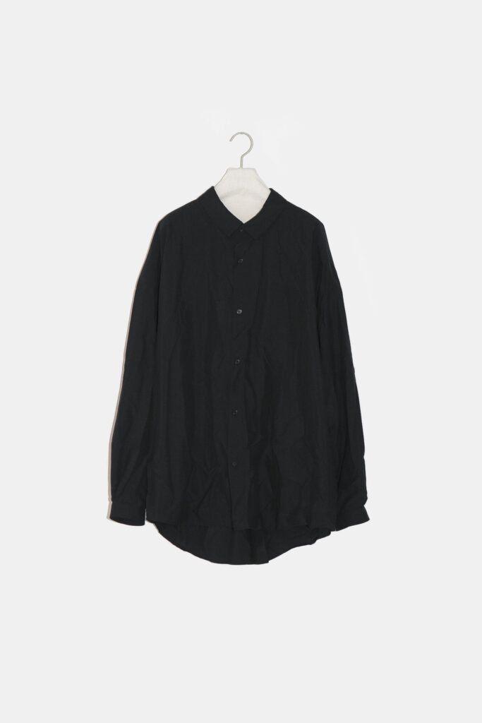 YOKO SAKAMOTO 21AW
REGULAR COLLAR SHIRT
レギュラーカラーのルーズフィットシャツ。シャツ専業工場でフラシ芯を使い非常に細かい運針で縫製したドレスライクな仕立て。また、製品洗いを施し、あえて何度か着た様なクタッとしたこなれた雰囲気に仕上げました。前身頃から後身頃にかけて、脇下に切替が無い一枚続きのノーシームパターンを採用した賛沢な仕様です。大きな生地を肩で羽織っている様な自然なドレープ感があり、タックインした時も、よりウエストにフィットします。